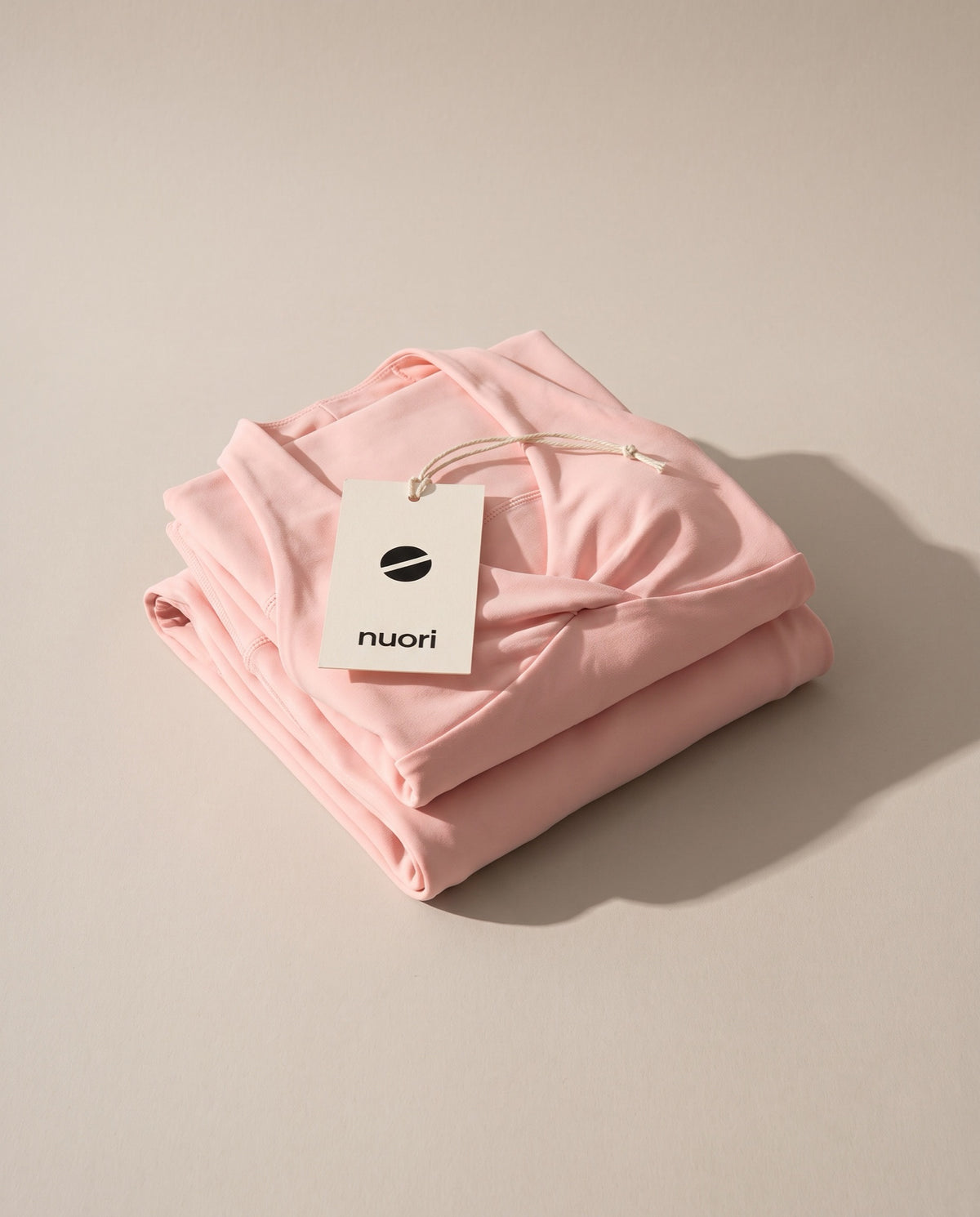 Pink legging and top folded with the nuori hang tag